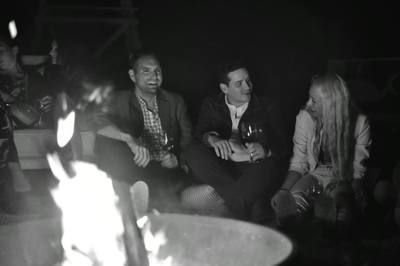 Friends chat by a bonfire in the Hamptons. 