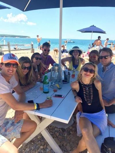 A group of friends on vacation relax for lunch on a private beach in the Hamptons. 
