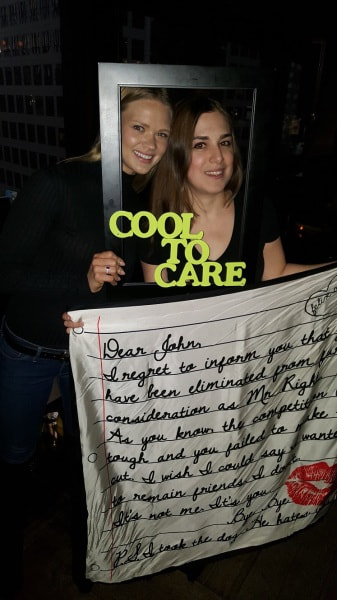 Two girls pose with props at a party in NYC. 