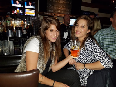 Two girls drink at the bar at one of the hottest parties in NYC for singles. 