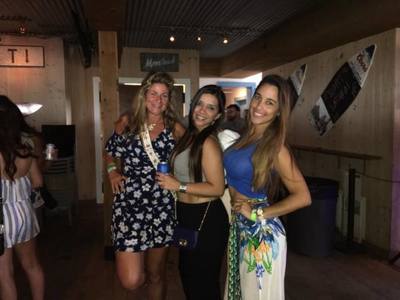 Three women having fun at a bar in the Hamptons. 